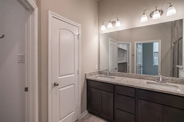 a bathroom with a granite countertop sink and a mirror