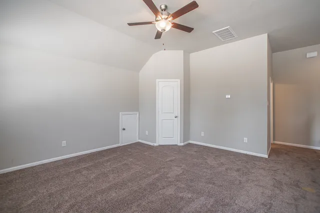 an empty room with closet and windows