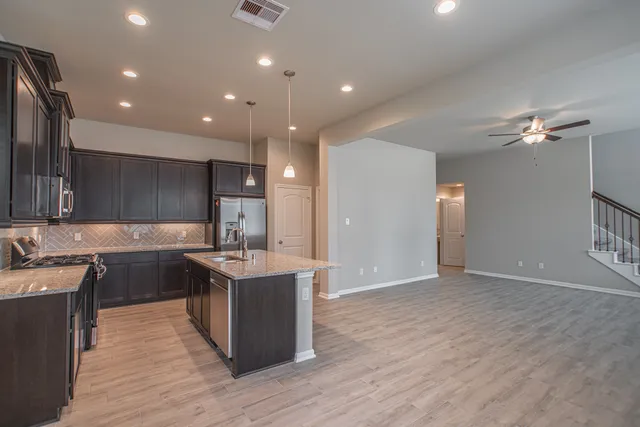 a kitchen with stainless steel appliances granite countertop a sink stove and refrigerator
