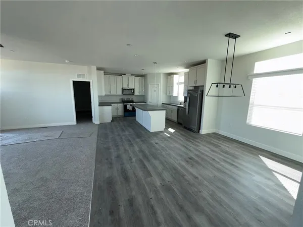 a kitchen with granite countertop a refrigerator stove top oven and sink