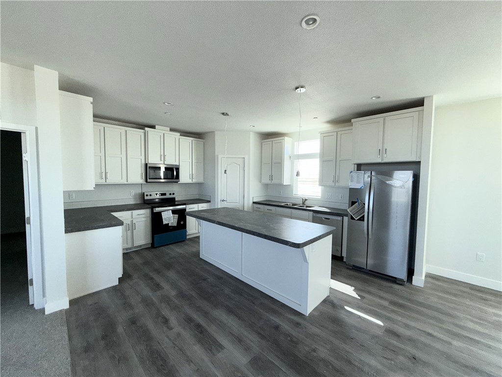 10633 Bromley Road Pinon Hills, CA 92372 - Photo 5 of 13 a kitchen with granite countertop a refrigerator stove top oven and sink