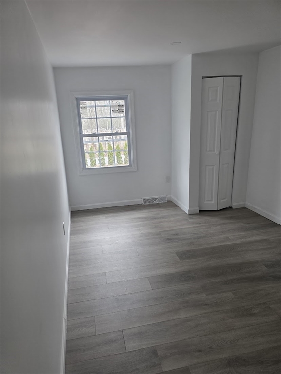 6 French Street, Unit AA Billerica, MA 01821 - Photo 11 of 16 an empty room with wooden floor and windows