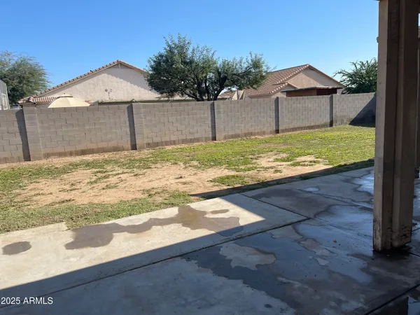 a view of a yard with wooden fence