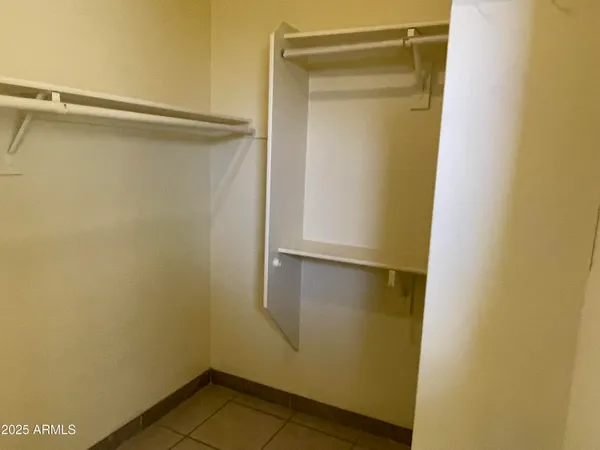 a view of walk in closet with empty racks