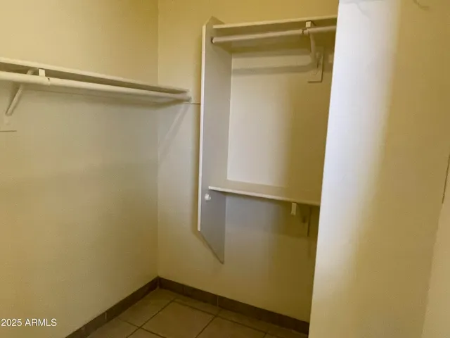 a view of walk in closet with empty racks