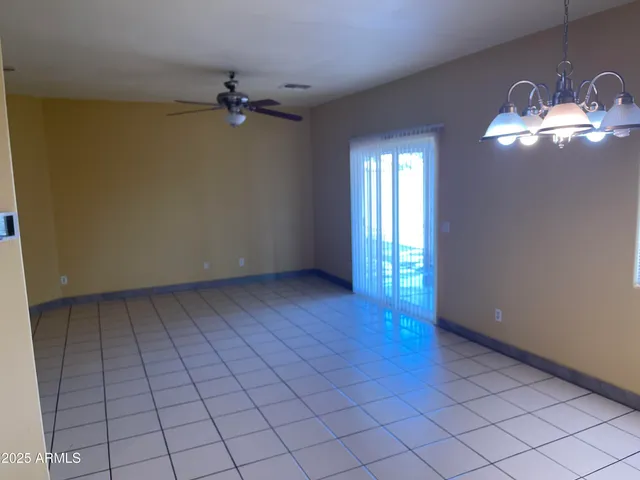 a view of a livingroom with a chandelier fan and window