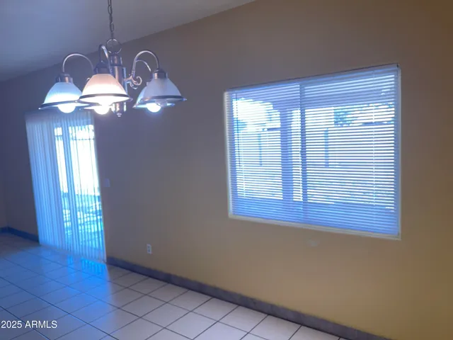 a view of a room with a chandelier fan and windows