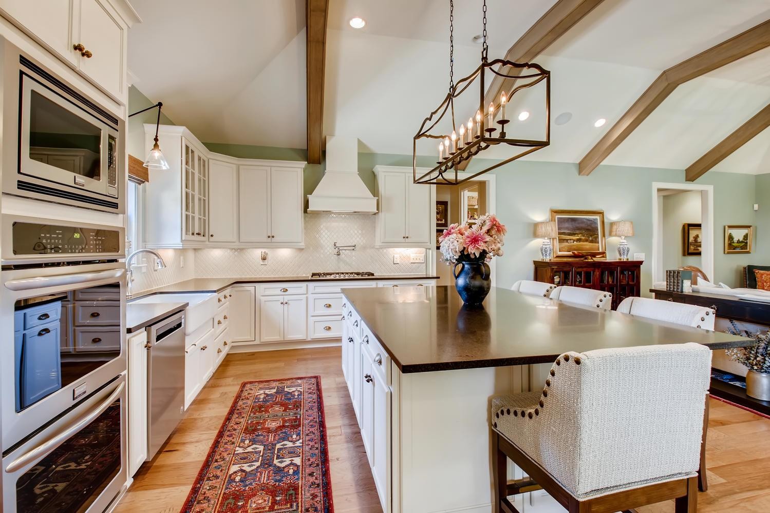 127 Vanner Road Mount Juliet, TN 37122 - Photo 9 of 29 a kitchen with stainless steel appliances granite countertop a sink dishwasher a stove top oven a dining table and chairs with wooden floor