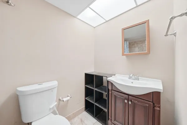 a bathroom with a toilet a sink and mirror