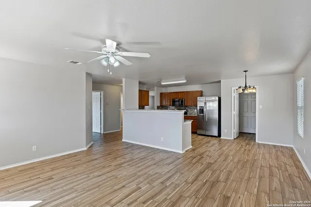 a view of a kitchen with wooden floor and a ceiling fan