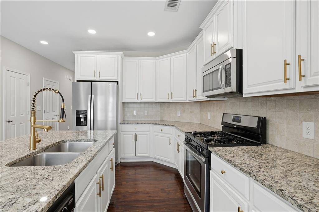 1221 Lavista Road Northeast Atlanta, GA 30324 - Photo 13 of 31 a kitchen with stainless steel appliances granite countertop a sink stove and refrigerator