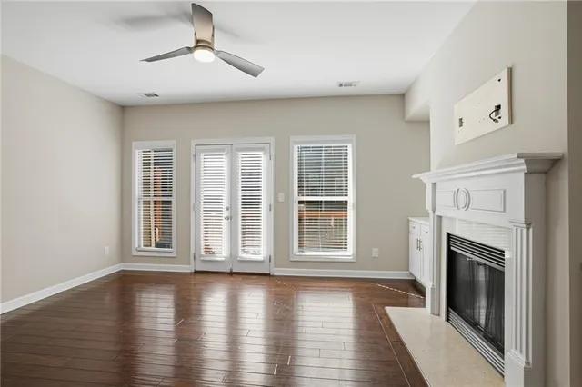a view of empty room with wooden floor and fireplace