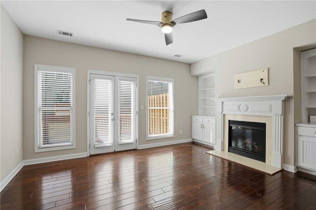 1221 Lavista Road Northeast Atlanta, GA 30324 - Photo 15 of 31 an empty room with wooden floor fireplace and windows