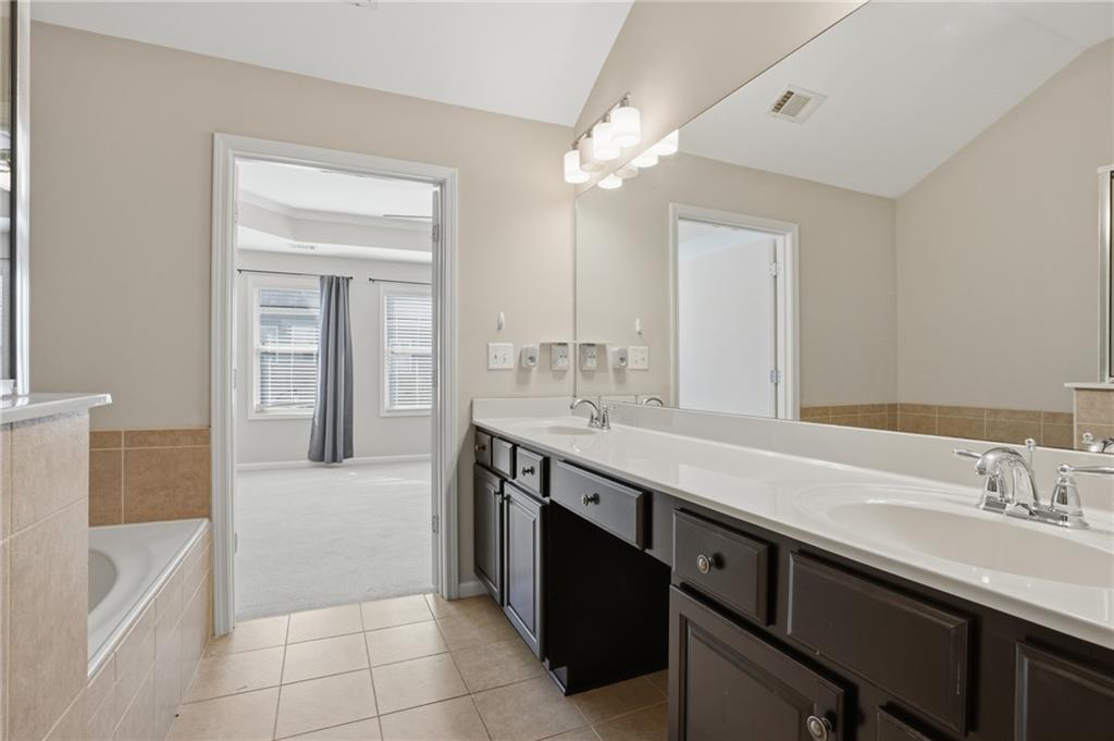 1221 Lavista Road Northeast Atlanta, GA 30324 - Photo 24 of 31 a spacious bathroom with a sink a vanity a mirror and bathtub