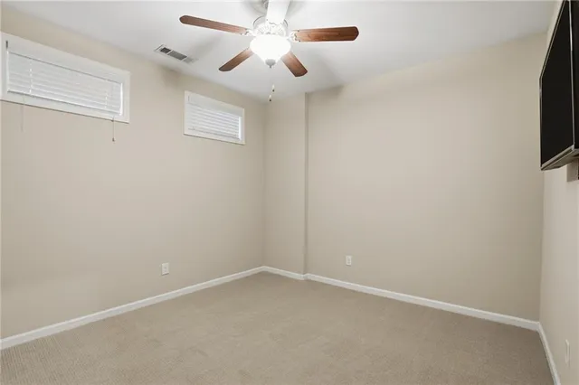 an empty room with a ceiling fan and a window