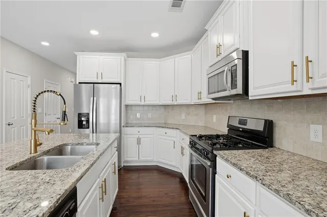 a kitchen with stainless steel appliances granite countertop a sink stove and refrigerator