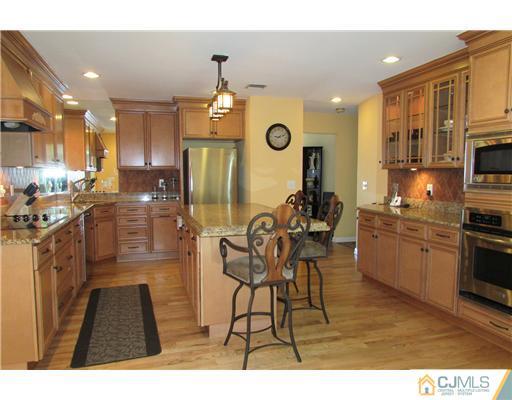 60 Club House Road Brick, NJ 08723 - Photo 4 of 23 a kitchen with stainless steel appliances kitchen island granite countertop a stove a sink a refrigerator and a microwave