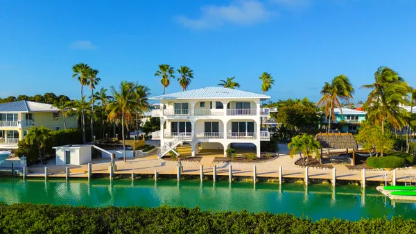 a kitchen with kitchen island granite countertop a sink and a refrigerator