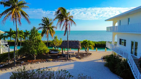 a view of a hallway with wooden floor and a bathroom