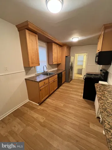 a large kitchen with stainless steel appliances granite countertop a sink and a stove