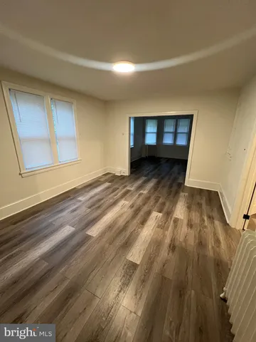 a view of a room with wooden floor and a window