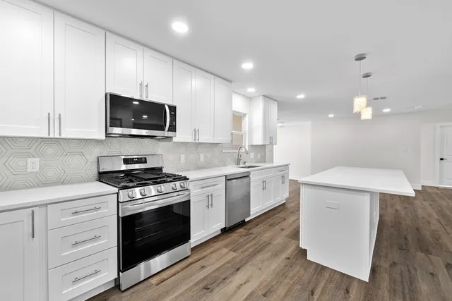 a kitchen with a stove a sink and a microwave