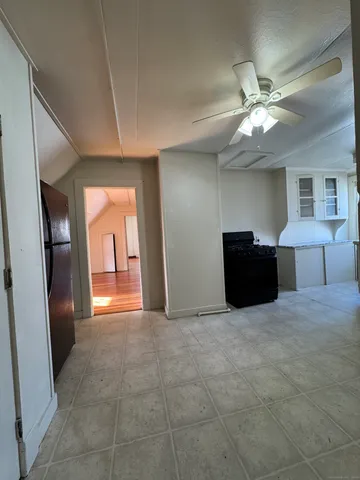 a view of an empty room and a kitchen