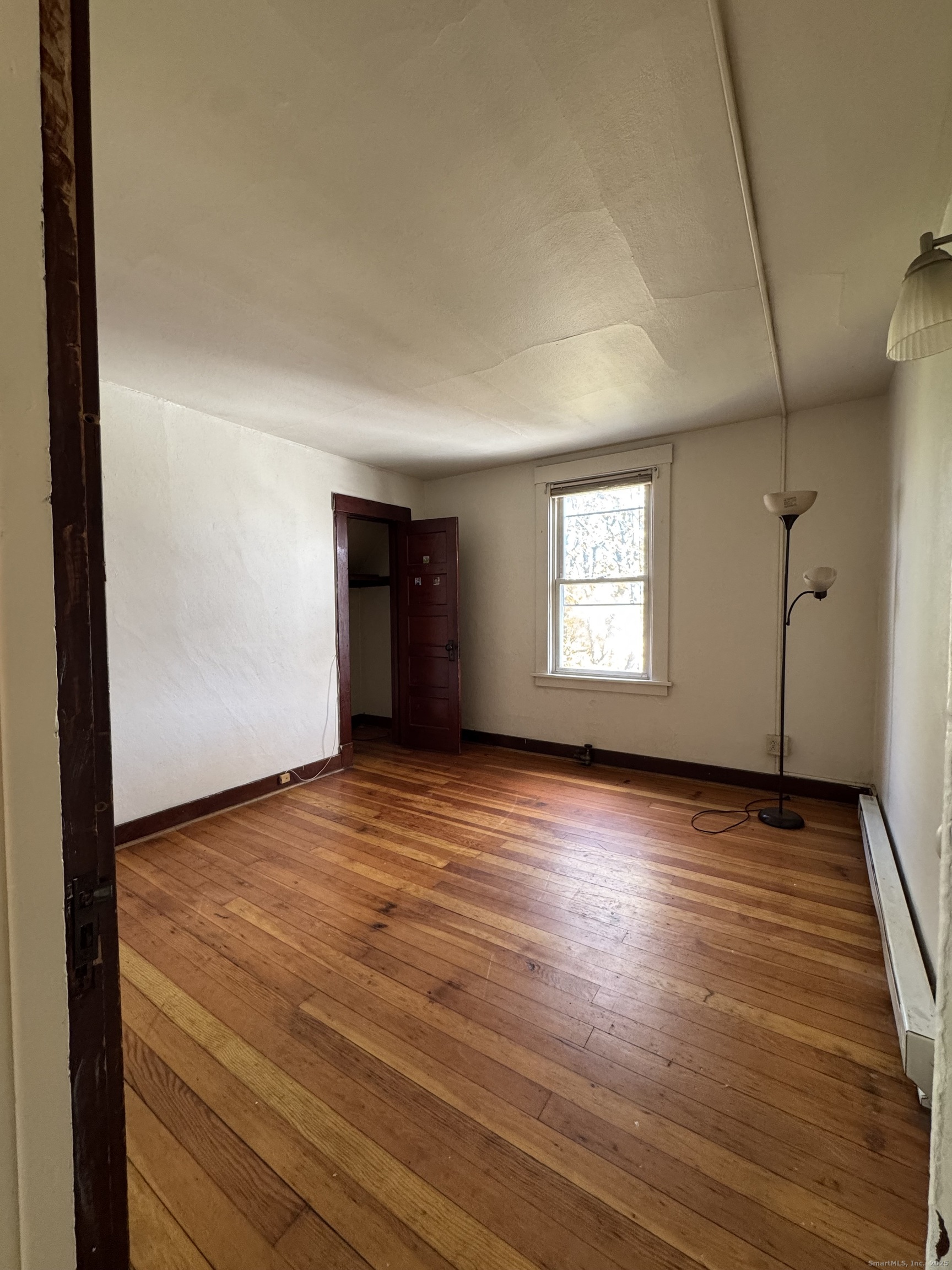 144 Montauk Avenue, Unit 3 New London, CT 06320 - Photo 7 of 8 an empty room with wooden floor and windows