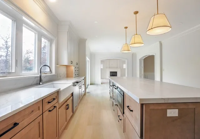 a large kitchen with granite countertop a sink dishwasher a stove and a dining table with wooden floor