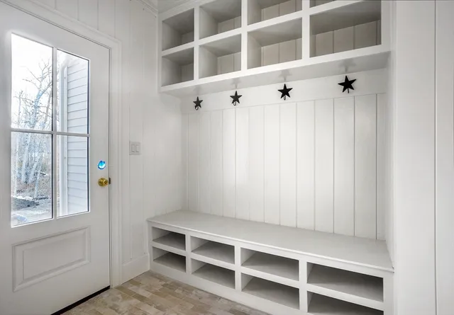 an empty room with windows and fireplace