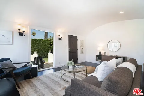 a living room with furniture potted plant and a large mirror