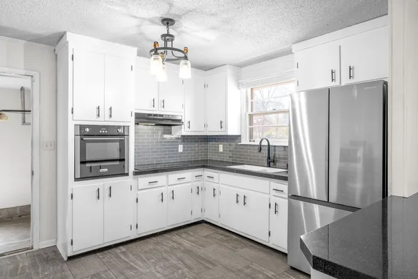 a kitchen with stainless steel appliances a refrigerator sink and cabinets