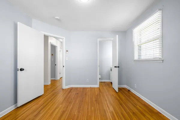 a view of a room with wooden floor and a window