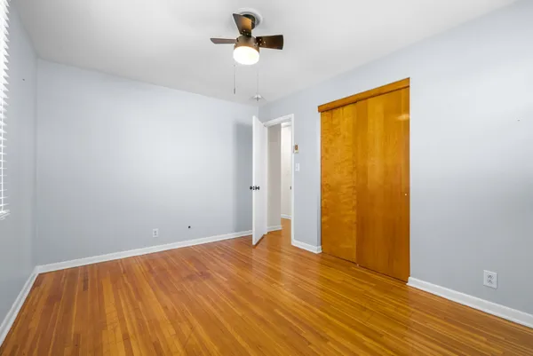 a view of room with wooden floor and ceiling fan