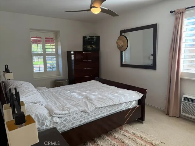 a bedroom with a bed and dresser with mirror