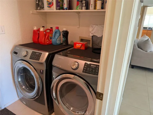 a utility room with dryer washer and a view of living room