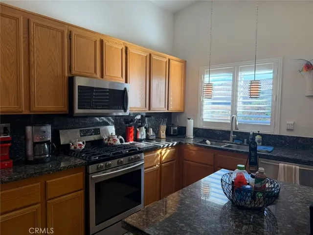 a kitchen with granite countertop a stove sink and cabinets