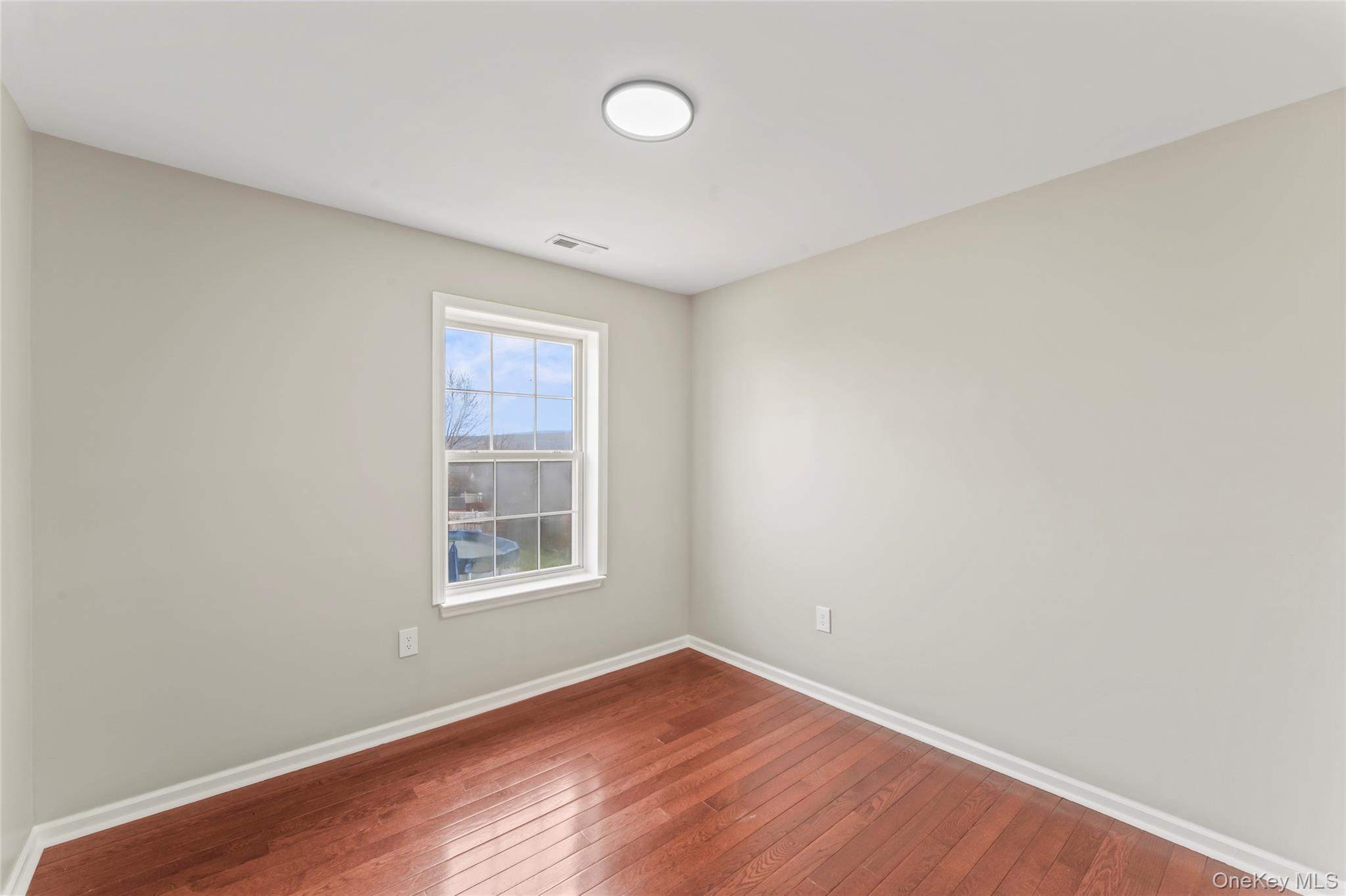 99 Evan Road Warwick, NY 10990 - Photo 17 of 27 an empty room with wooden floor and windows