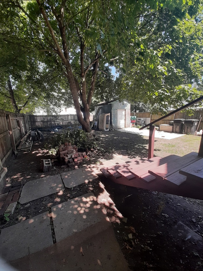 1402 South Wright Street Bloomington, IL 61701 - Photo 8 of 20 a backyard of a house with table and chairs under a large tree