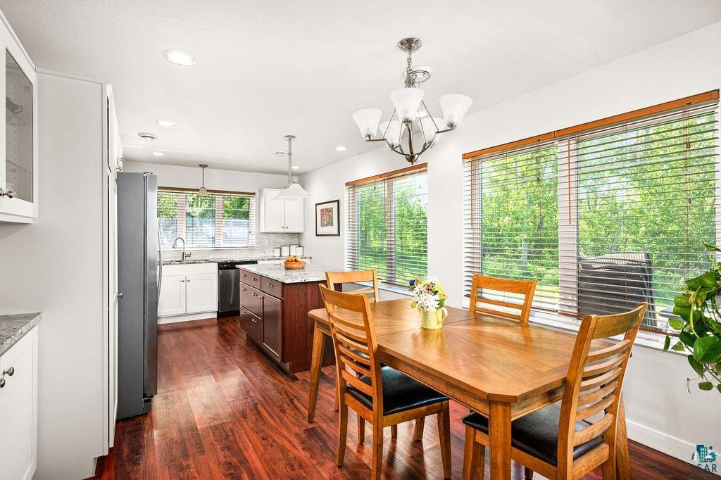 3825 Kenroy Road Hermantown, MN 55811 - Photo 5 of 28 Dining room with a notable chandelier, sink, and dark wood-type flooring