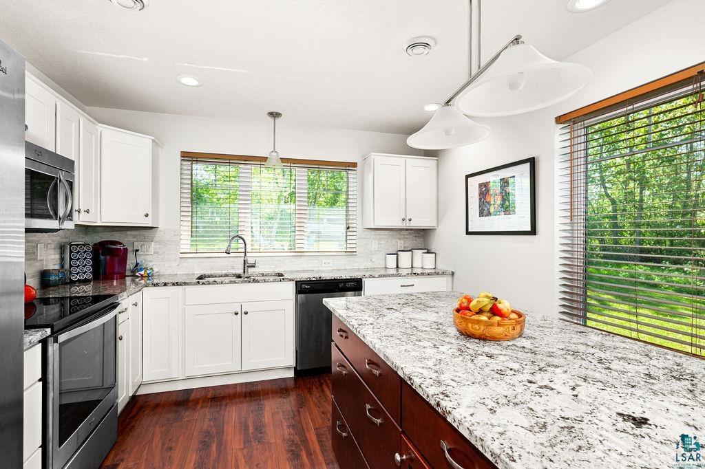 3825 Kenroy Road Hermantown, MN 55811 - Photo 6 of 28 Kitchen featuring tasteful backsplash, dark hardwood / wood-style flooring, sink, a wealth of natural light, and appliances with stainless steel finishes