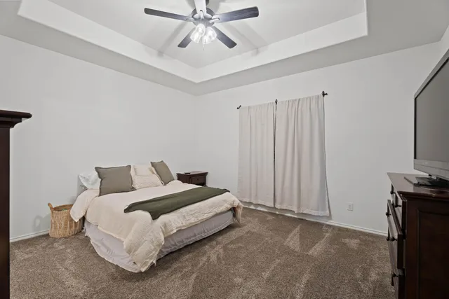 a spacious bedroom with a bed and a tv