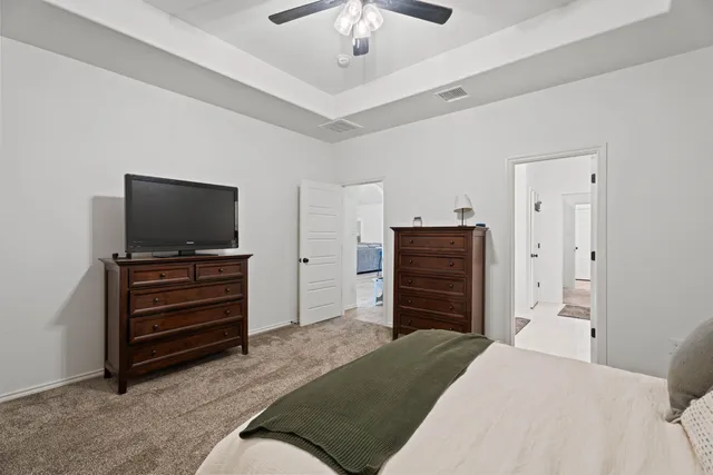 a bedroom with a dresser and a flat screen tv