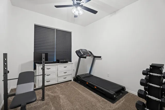 a room with gym equipment and wooden floor