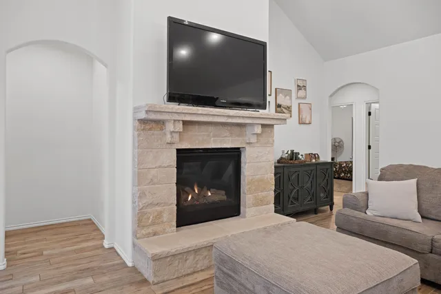 a living room with furniture a flat screen tv and a fireplace