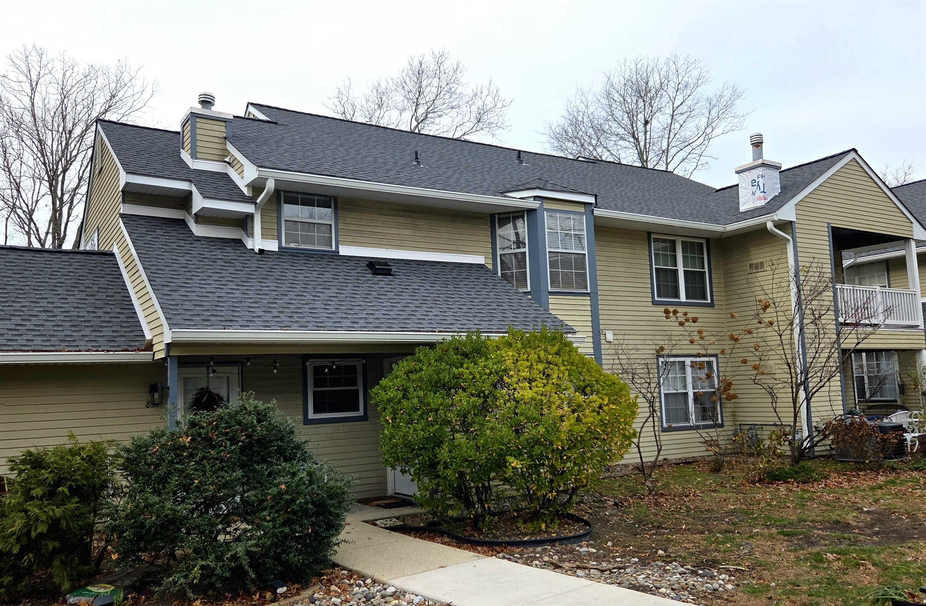 a brick house with a large windows and a yard table and chairs