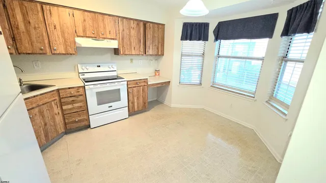 a kitchen with a refrigerator a stove a sink and a window
