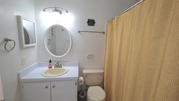 a bathroom with a sink vanity mirror and toilet