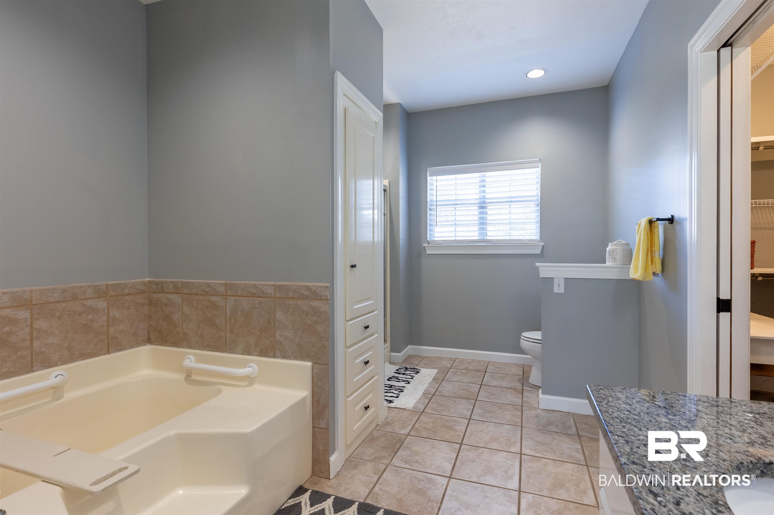 6436 Cherry Ridge Court West Mobile, AL 36695 - Photo 10 of 26 Bathroom with a spacious closet, toilet, baseboards, tile patterned floors, and a garden tub