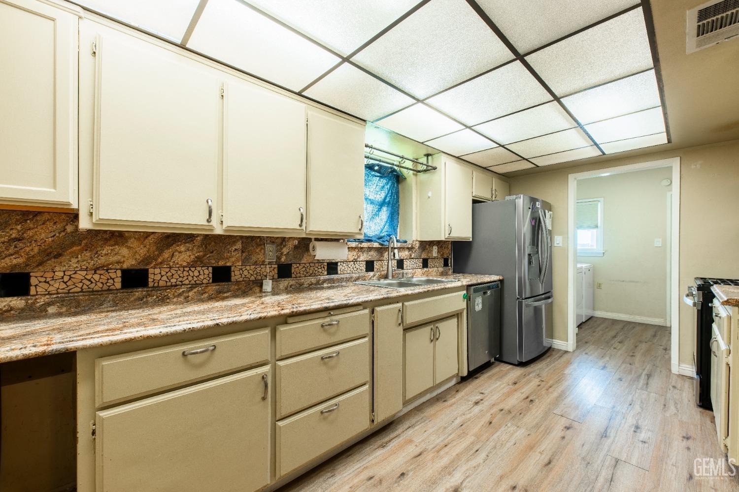 Undisclosed Address Bakersfield, CA 93305 - Photo 11 of 27 a kitchen with a sink and refrigerator